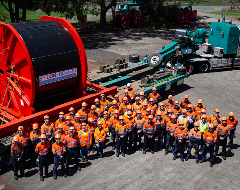 An image of the Bridon-Bekaert Ropes Group Australia Team standing in front of one of our large wire rope reels destined for a cable run conveyor. 